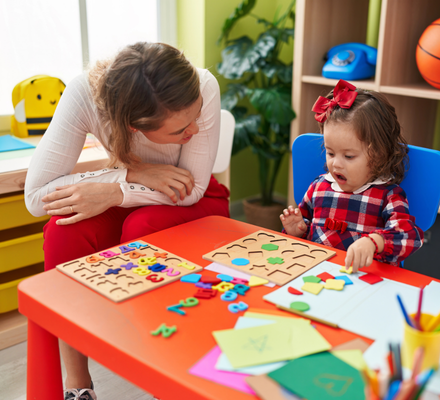 Toddler doing shape puzzles with a therapist