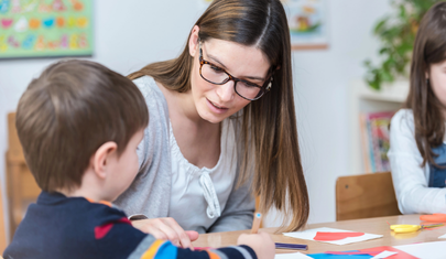 BCBA guiding a child through a learning activity