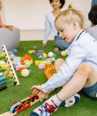 Boy playing with a toy train and building blocks