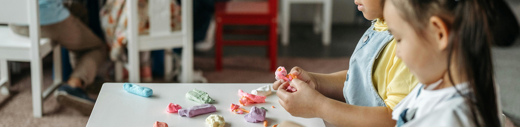 Kids molding clay at a play table